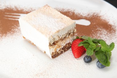 Tabağında böğürtlen olan tiramisu tatlısı.