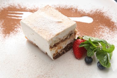 Tabağında böğürtlen olan tiramisu tatlısı.