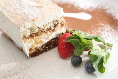 Tabağında böğürtlen olan tiramisu tatlısı.