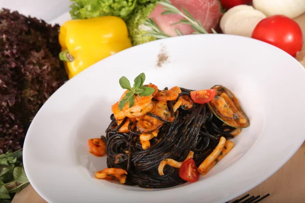 Black spaghetti with seafood on plate