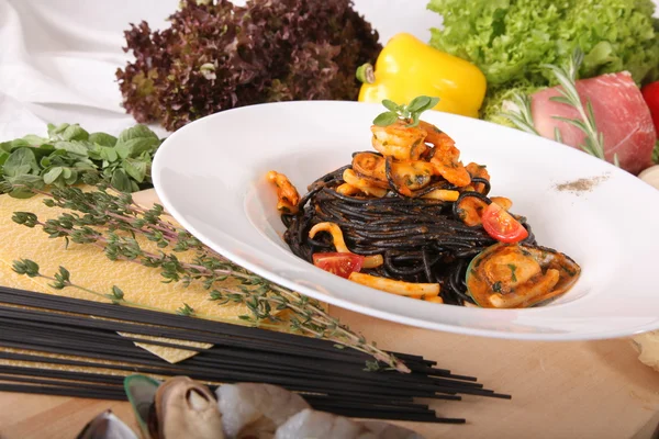 Black spaghetti with seafood on plate