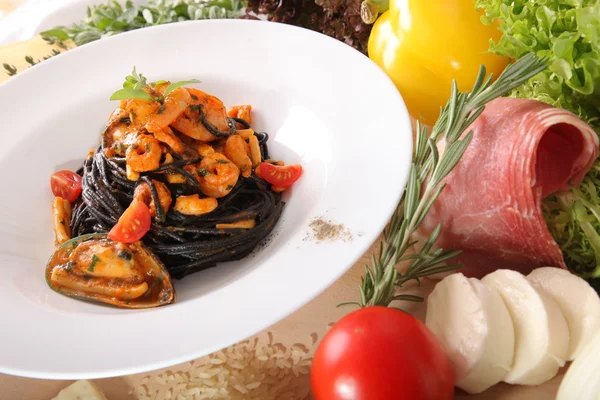 Black spaghetti with seafood on plate