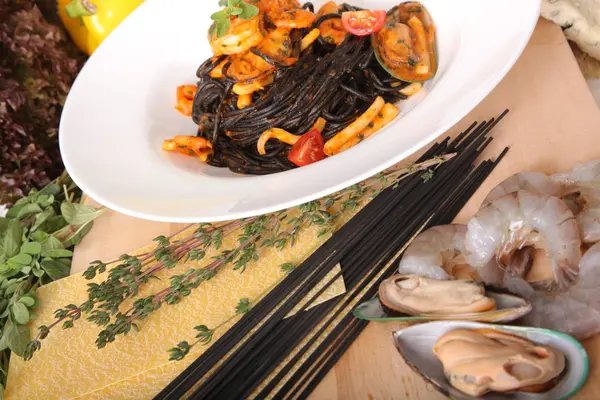 Black spaghetti with seafood on plate