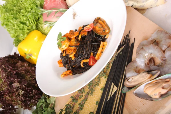 Black spaghetti with seafood on plate
