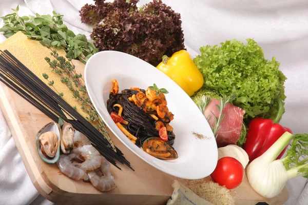 Black spaghetti with seafood on plate