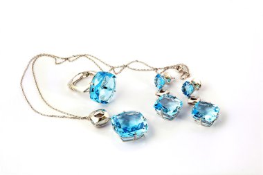 Beyaz zemin üzerinde değerli taşlar olan mücevherler.