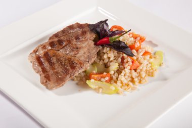 Beyaz tabakta domuz eti pişirme teknolojisi.