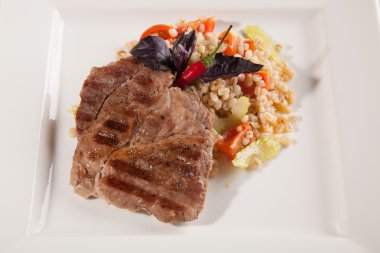 Beyaz tabakta domuz eti pişirme teknolojisi.