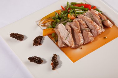 Beyaz tabakta çam kozalağı soslu ördek