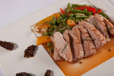 Beyaz tabakta çam kozalağı soslu ördek