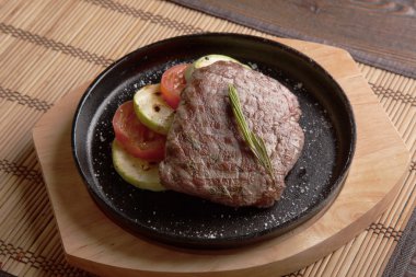 Sıcak siyah tavada biftek alevi.