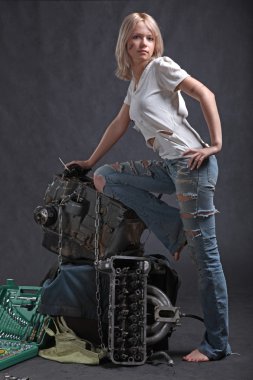 Siyah arka planda ingiliz anahtarı olan motor yağındaki kız