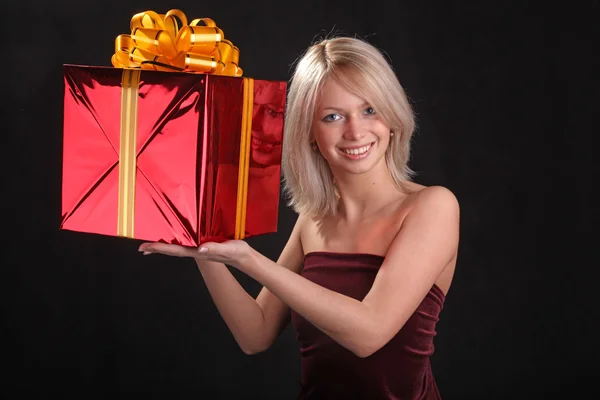 blonde with a gift in the hands on black background
