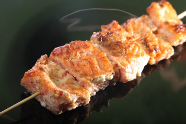 Siyah bir tabakta şiş üzerinde et