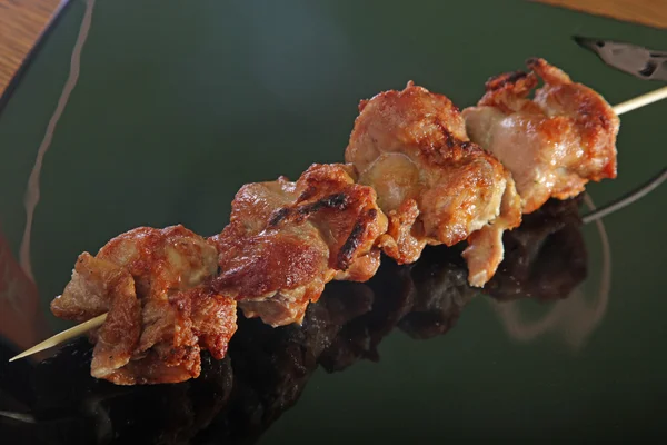黒い皿の上の串焼きの肉 — ストック写真