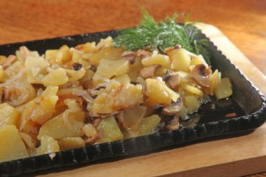 fried potatoes on a hot black frying pan