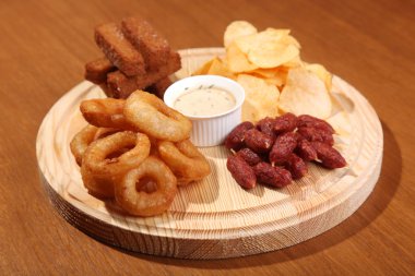 Tahta kesme tahtası ve ahşap masa üzerinde bira için atıştırmalıklar