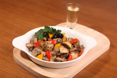 Mantarlı et ve tahta tabakta bir bardak votka.