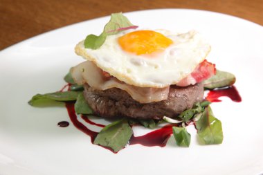 Kızarmış yumurta ve soslu biftek.