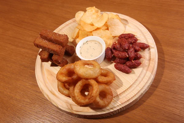 snacks to beer on a wooden cutting board and wooden table