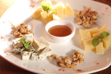 Tabakta farklı peynirler, ceviz ve bal var.