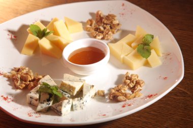 Tabakta farklı peynirler, ceviz ve bal var.