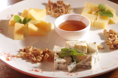 Tabakta farklı peynirler, ceviz ve bal var.