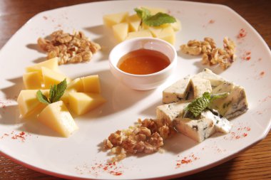 Tabakta farklı peynirler, ceviz ve bal var.