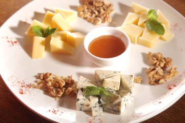 Tabakta farklı peynirler, ceviz ve bal var.