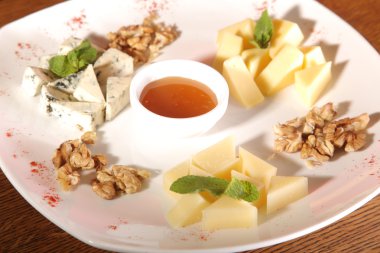 Tabakta farklı peynirler, ceviz ve bal var.