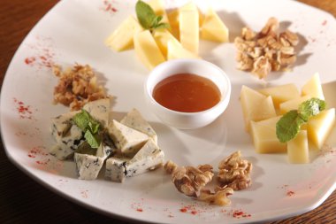 Tabakta farklı peynirler, ceviz ve bal var.