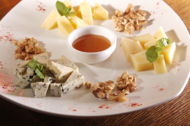 Tabakta farklı peynirler, ceviz ve bal var.