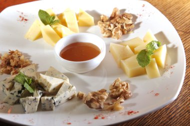 Tabakta farklı peynirler, ceviz ve bal var.