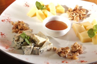 Tabakta farklı peynirler, ceviz ve bal var.