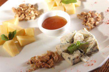 Tabakta farklı peynirler, ceviz ve bal var.