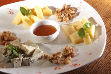 Tabakta farklı peynirler, ceviz ve bal var.