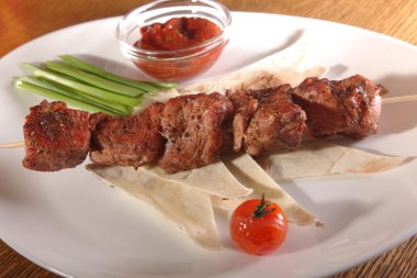 Bir parça ekmek ve tabakta sos şiş.