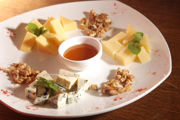 Tabakta farklı peynirler, ceviz ve bal var.