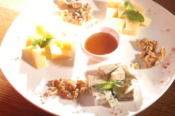 Tabakta farklı peynirler, ceviz ve bal var.