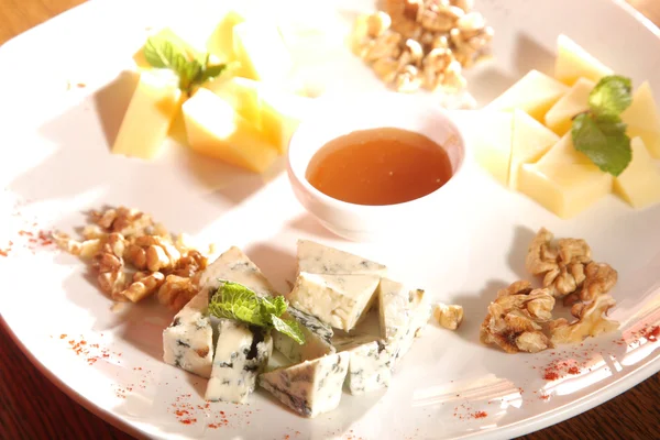 Tabakta farklı peynirler, ceviz ve bal var.