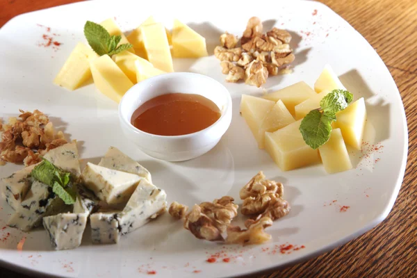 Tabakta farklı peynirler, ceviz ve bal var.