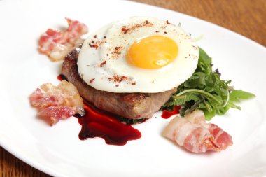 Kızarmış yumurta ve soslu biftek.