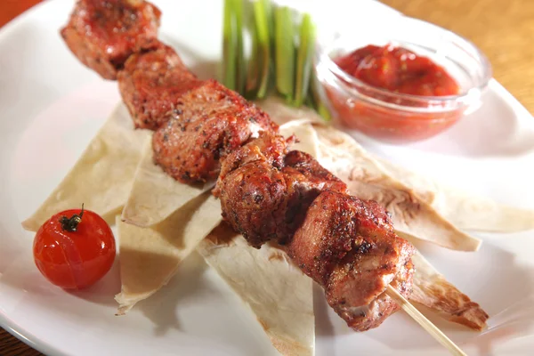 Bir parça ekmek ve tabakta sos şiş.