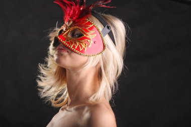 Siyah arka planda güzel bir boynu olan maskeli bir sarışın.