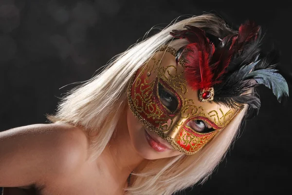 emotions on the face of the girl in the Venetian mask on black background