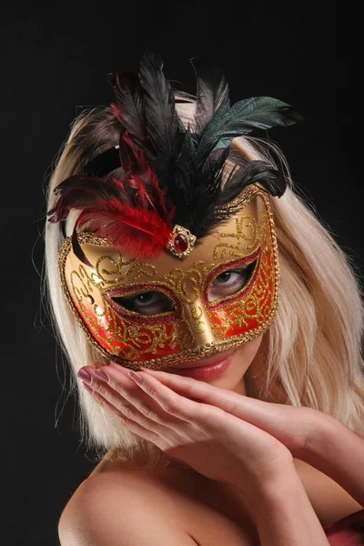 emotions on the face of the girl in the Venetian mask on black background