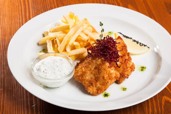 dish of meat in batter and fried potatoes on plate