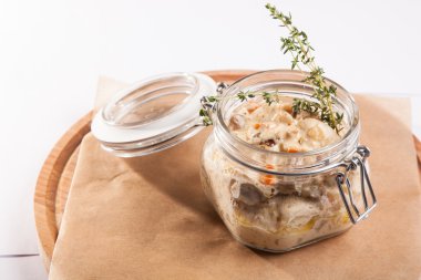 Beyaz arka plan üzerinde ahşap bir tabakta tencerede rosto