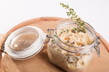 Beyaz arka plan üzerinde ahşap bir tabakta tencerede rosto