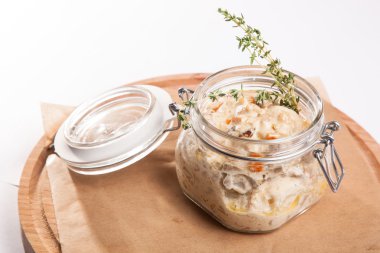 Beyaz arka plan üzerinde ahşap bir tabakta tencerede rosto